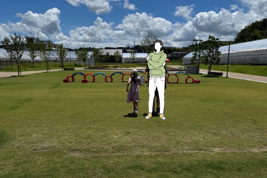 歯車のような形の遊具に向かって走っていく親子