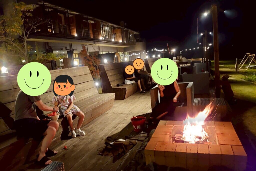 キャプファイヤーを囲みながら家族でスイカを食べて話している様子