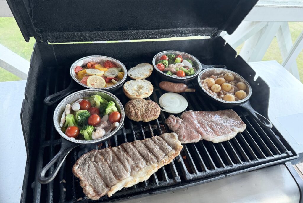 お肉やアヒージョや野菜などをBBQコンロで焼いている様子