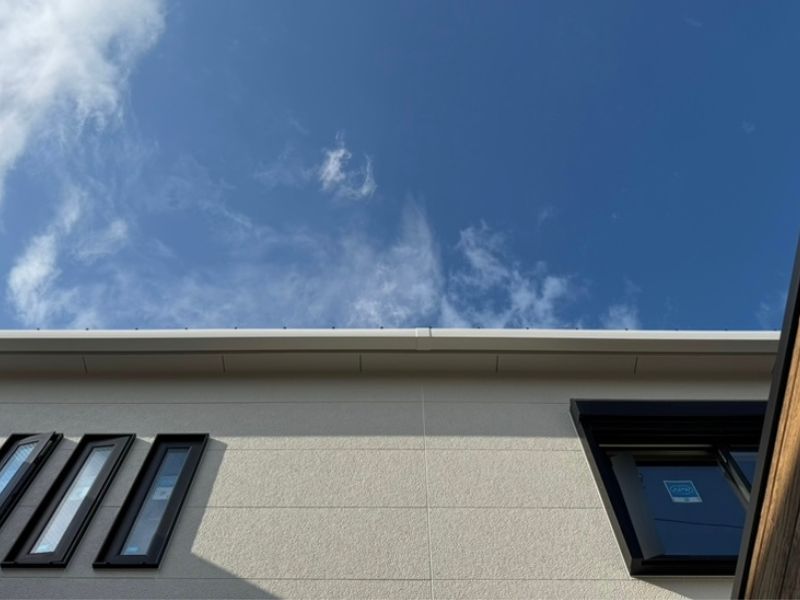 新居の中庭から見上げた外壁と青空の写真